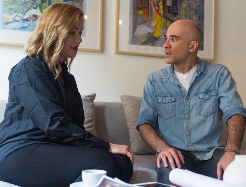 Architect and his client discussing renovation project. Middle aged man and woman sitting on couch at home and talking. Interior designer and customer concept
